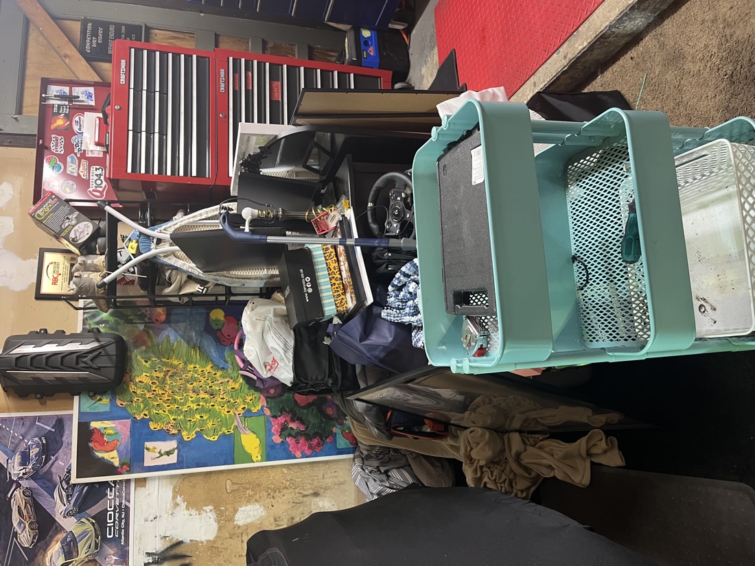 Before garage cleanout in Monroe, NJ: a garage crammed with bins, tools, posters and clutter